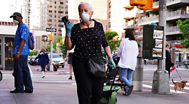 A woman walks while wearing a protective mask during the coronavirus pandemic on May 16, 2020 in New York City. Coronavirus NYC