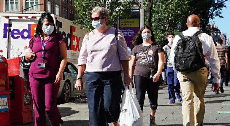 People walk while wearing protective masks as New York City moves into Phase 3 of re-opening following restrictions imposed to curb the coronavirus pandemic on July 14, 2020. Coronavirus NYC