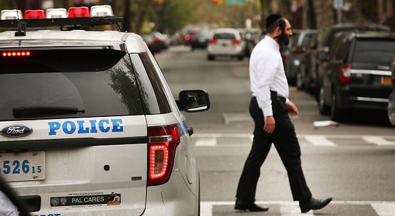 A Hasidic man walks through a Jewish Orthodox neighborhood in Brooklyn. Hasidic NYPD