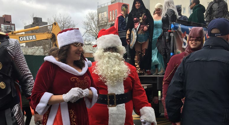 Santa and the superheroes paraded through Brooklyn to hand out thousands of presents. Santa NYPD