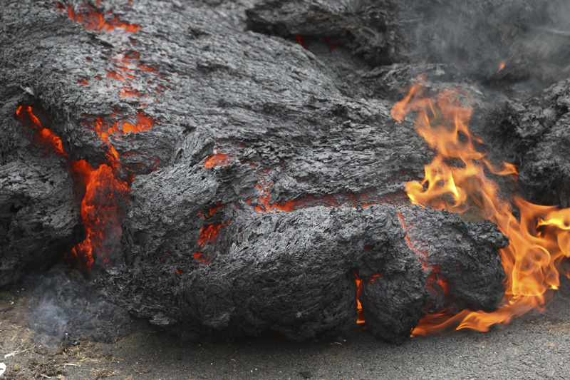 In this May 5, 2018, file photo, lava burns across a road in the Leilani Estates subdivision near Pahoa, Hawaii. The lava hisses, crackles and pops. It roars like an engine as it sloshes and bubbles. In this May 5, 2018, file photo, lava burns across a road in the Leilani Estates subdivision near Pahoa, Hawaii. The lava hisses, crackles and pops. It roars like an engine as it sloshes and bubbles.