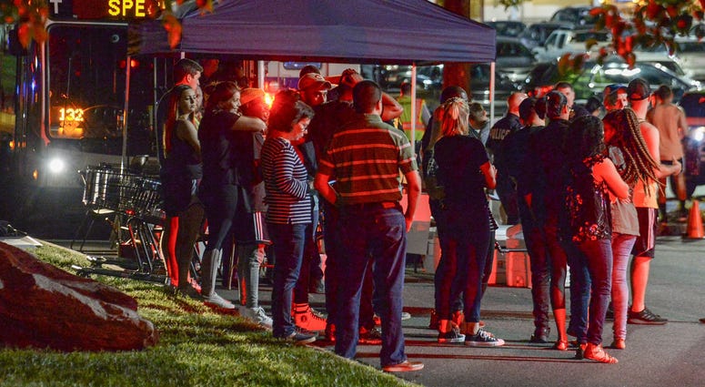 Students wait for bus rides from a strip mall parking lot, back to campus after a two died in a campus shooting at University of North Carolina-Charlotte in Charlotte Tuesday, April 30, 2019. Charlotte shooting