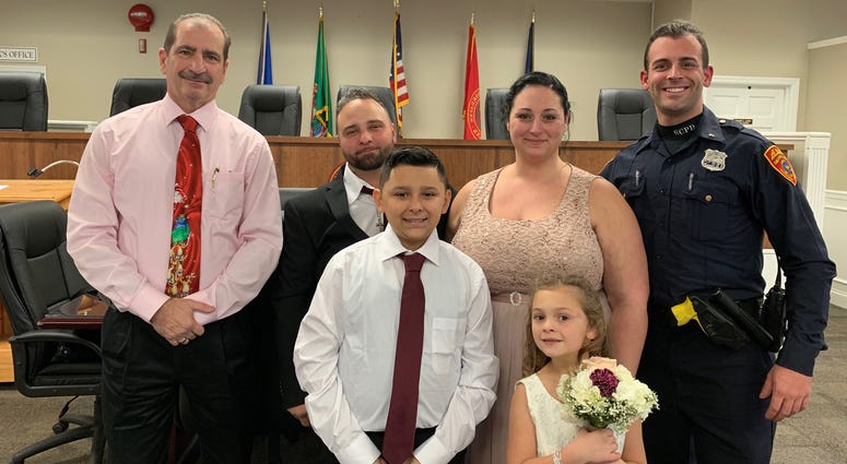 The happy family and Officer Cody Matthews. Cop drives couple to wedding