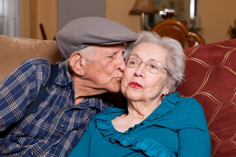 Elderly senior couple in an affectionate pose in a home setting. Elderly senior couple in an affectionate pose in a home setting.