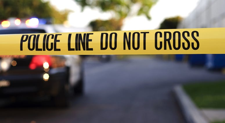 Yellow police tape at a crime scene with a police car in the background. police tape
