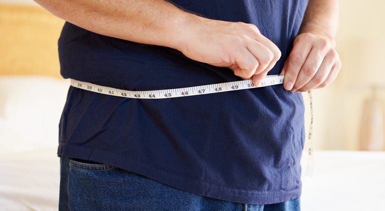 Close Up Of Overweight Man Measuring Waist Close Up Of Overweight Man Measuring Waist