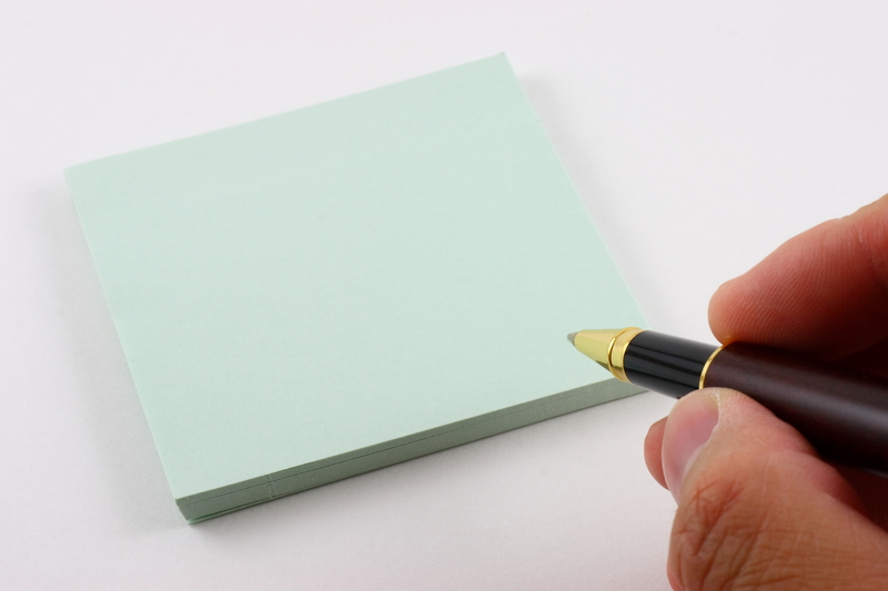 A hand preparing to write a note. A hand preparing to write a note.