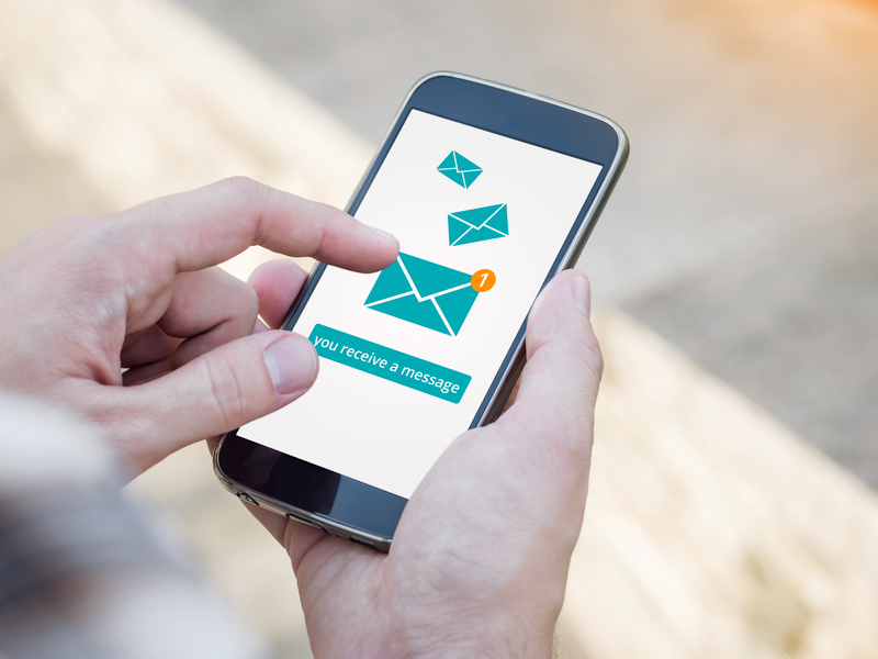 Email app on smartphone screen. You receive a message, New message is received. Man's Hand holding a smartphone Email app on smartphone screen. You receive a message, New message is received. Man's Hand holding a smartphone
