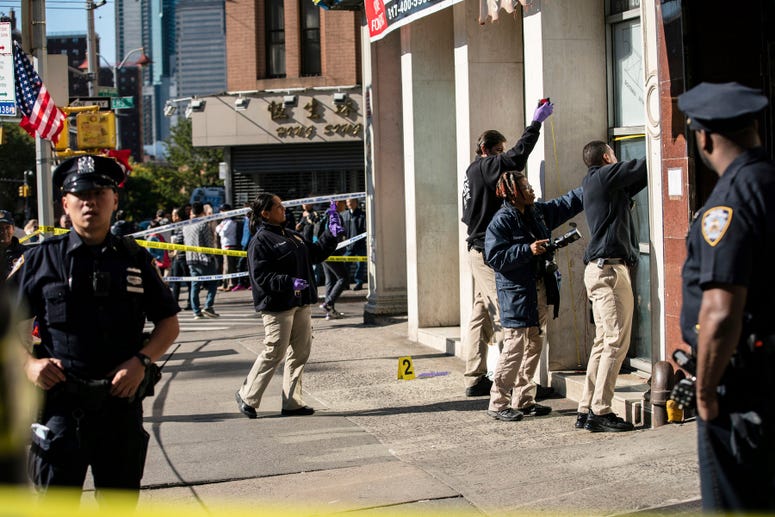 New York Police Department officers investigate the scene of an attack in Manhattan's Chinatown neighborhood, Saturday, Oct. 5, 2019 in New York. Chinatown homeless killings