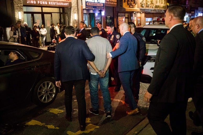 Police officers escort Randy Rodriguez Santos from the 5th Precinct to a vehicle bound for a hospital for evidence collection, Saturday, Oct. 5, 2019, in New York. Chinatown homeless killings