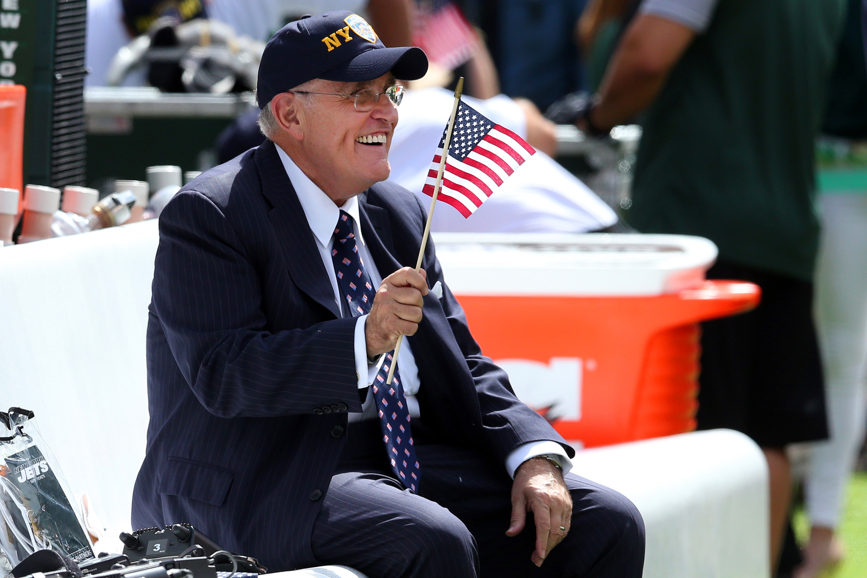 Sep 11, 2016; East Rutherford, NJ, USA; New York City former mayor Rudy Giuliani waves an American flag while sitting on the Jets bench before a game between the New York Jets and the Cincinnati Bengals at MetLife Stadium. Sep 11, 2016; East Rutherford, NJ, USA; New York City former mayor Rudy Giuliani waves an American flag while sitting on the Jets bench before a game between the New York Jets and the Cincinnati Bengals at MetLife Stadium.