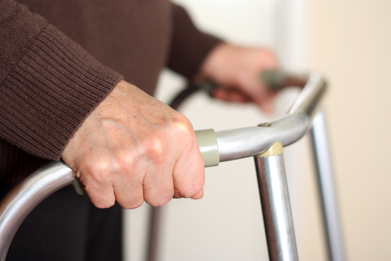 An elderly person using a walker. An elderly person using a walker.