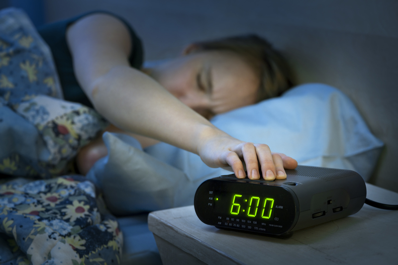 Woman uses an alarm clock. Woman uses an alarm clock.