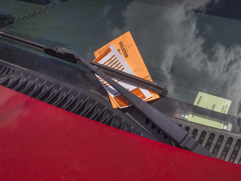 A parking ticket stuck in a windshield. A parking ticket stuck in a windshield.