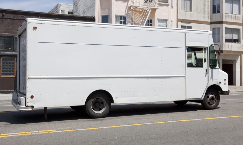 Side view of white delivery truck parked on city street. Side view of white delivery truck parked on city street.