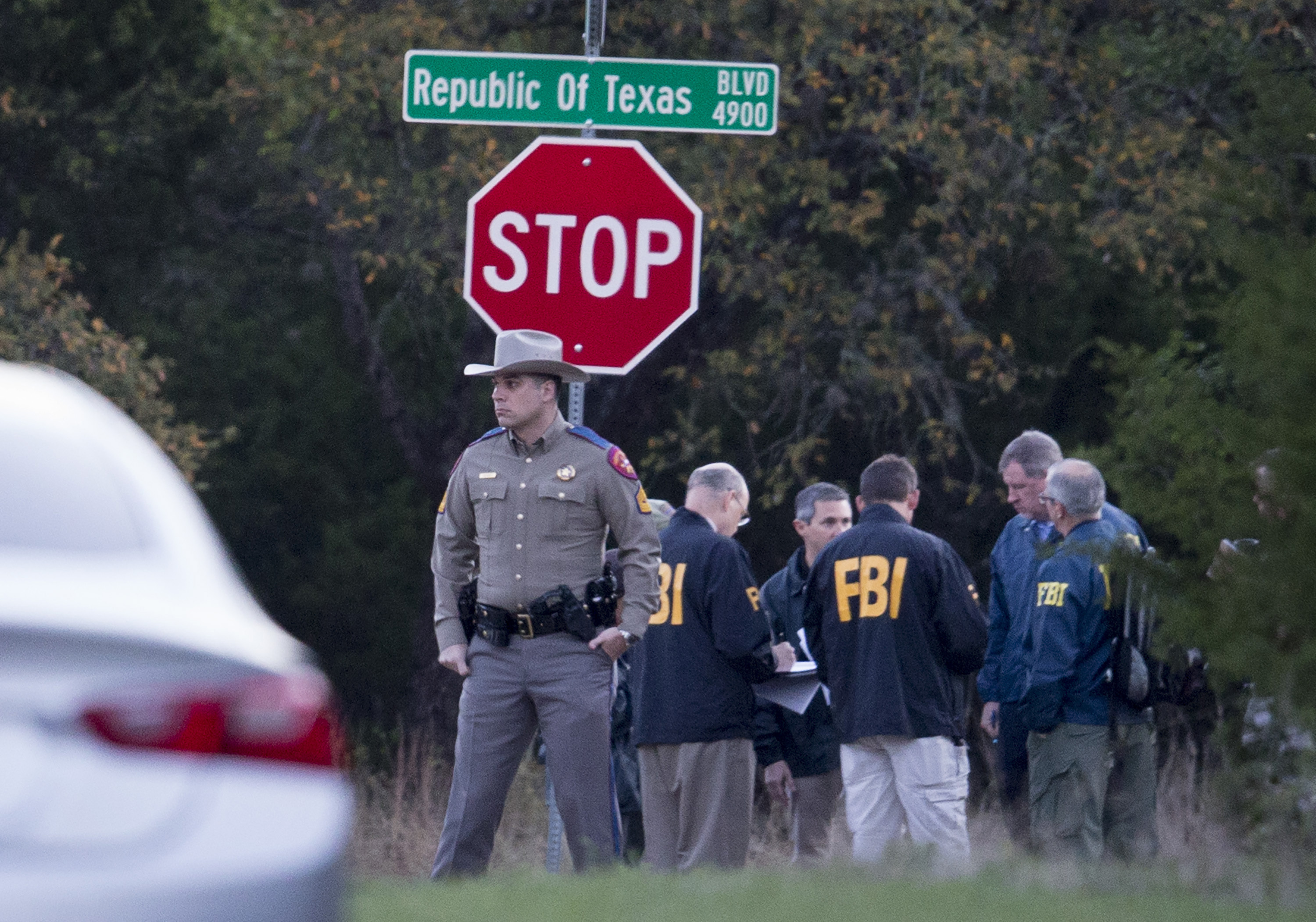 Law enforcement officers gather at the intersection of Republic of Texas and Mission Oaks boulevards in the the Travis Country neighborhood of Austin, Texas to investigate a bombing on March 19.
