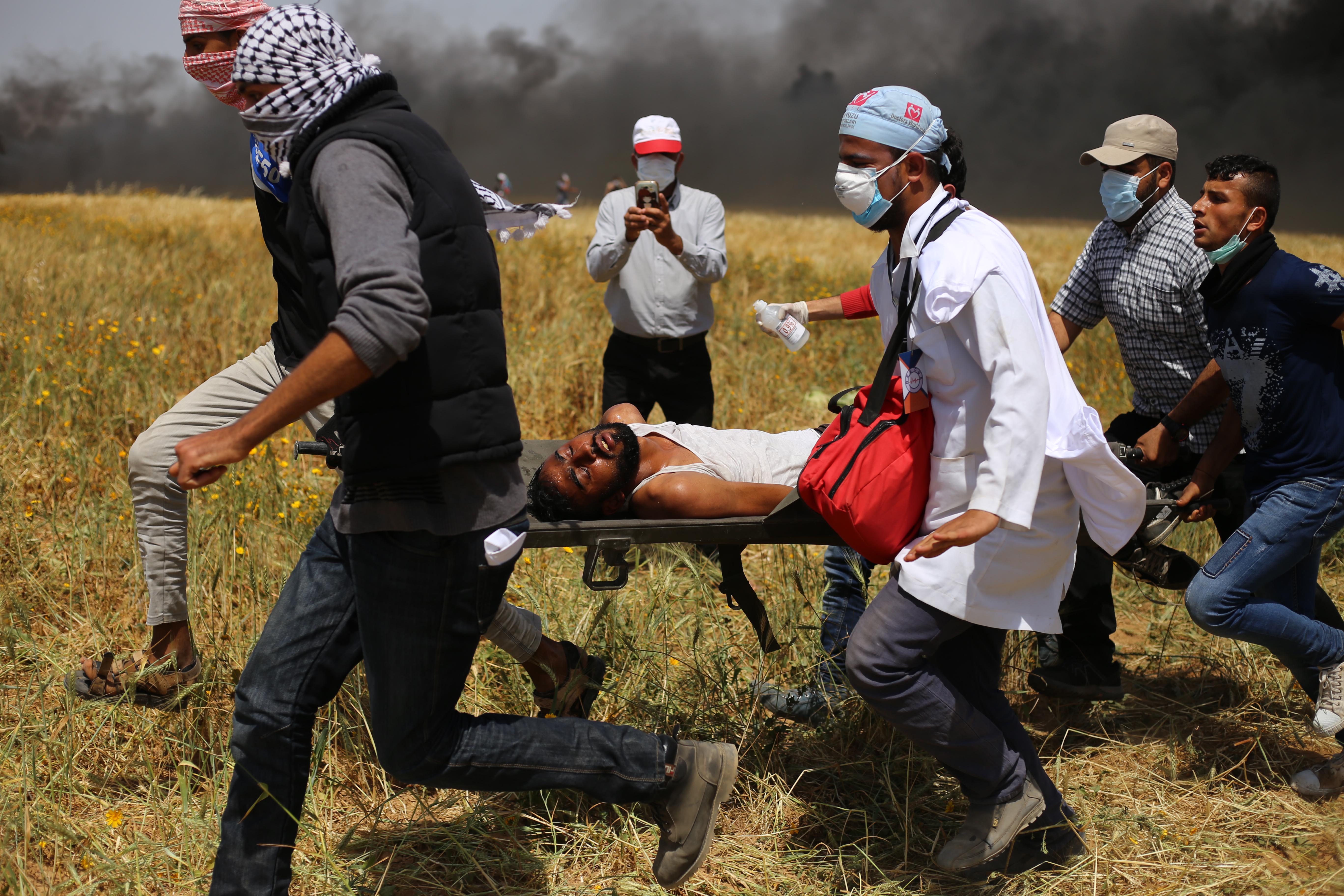 GAZA, April 6, 2018 (Xinhua) -- Palestinian protesters carry an injured man during clashes on the Gaza-Israel border, east of Gaza City on April 6, 2018. Hundreds of Palestinian demonstrators began Friday to set fire to dozens of car tires near the border GAZA, April 6, 2018 (Xinhua) -- Palestinian protesters carry an injured man during clashes on the Gaza-Israel border, east of Gaza City on April 6, 2018. Hundreds of Palestinian demonstrators began Friday to set fire to dozens of car tires near the border