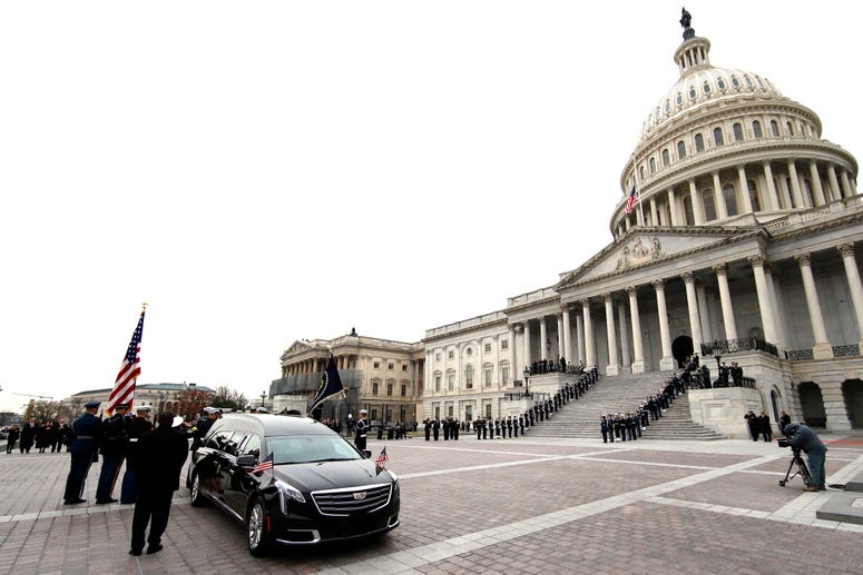 The flag-draped casket of former President George H.W. Bush is carried by a joint services military honor guard from the U.S. Capitol, Wednesday, Dec. 5, 2018, in Washington. George H.W. Bush