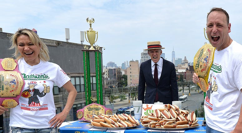 Competitive eaters Miki Sudo (l) and Joey Chestnut (r) each hold a tray of hot dogs with their respective records, 41 and 74, during the weigh-in before Nathan's Famous July Fourth hot dog eating contest. Joey Chestnut