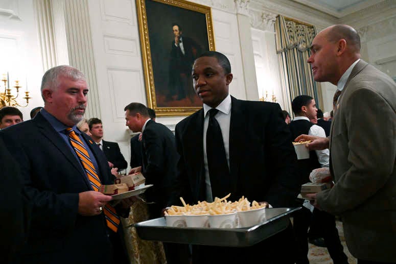 Guests attending a reception for the Clemson Tigers watch as more French fries are brought out to the State Dining Room of the White House in Washington, Monday, Jan. 14, 2019. Trump McDonalds
