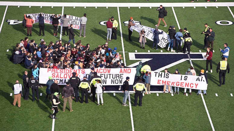 Demonstrators stage a climate change protest at the Yale Bowl delaying the start of the second half of an NCAA college football game between Harvard and Yale Saturday, Nov. 23, 2019, in in New Haven, Conn. Protest