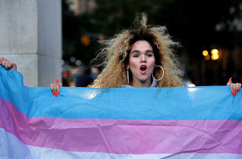Morgin Dupont, 25, a woman of trans experience, holds up the flag for Transgender and Gender Noncomforming people at a rally for LGBTQI+ rights at Washington Square Park on October 21, 2018 in New York City. Yana Paskova/Getty Images