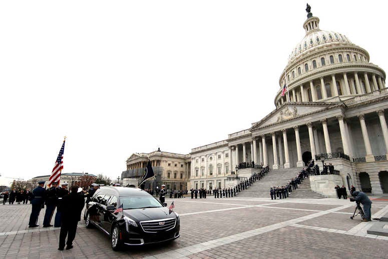 The flag-draped casket of former President George H.W. Bush is carried by a joint services military honor guard from the U.S. Capitol, Wednesday, Dec. 5, 2018, in Washington. George H.W. Bush