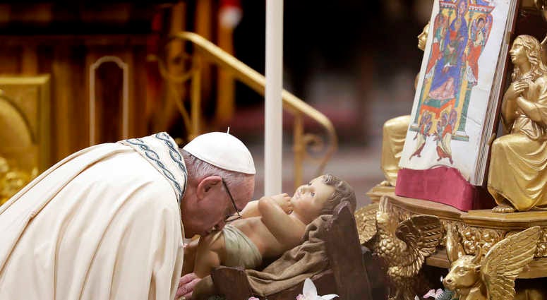 Pope Francis kisses a statue of Baby Jesus as he celebrates a new year's eve vespers Mass in St. Peter's Basilica at the Vatican, Monday, Dec. 31, 2018. New Year Vatican