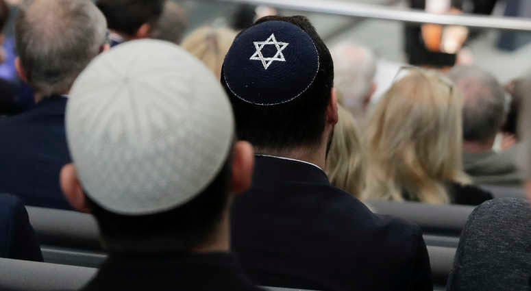 Two men wearing skullcaps as they listen to the speech of Israeli Historian Saul Friedlaender. Skullcap