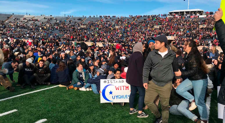 Demonstrators stage a protest on the field at the Yale Bowl disrupting the start of the second half of an NCAA college football game between Harvard and Yale, Saturday, Nov. 23, 2019, in in New Haven, Conn. Climate protest Yale Harvard game