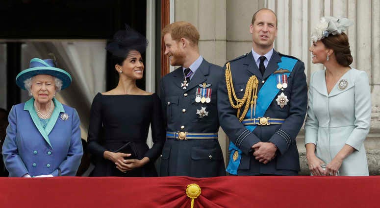 In this Tuesday, July 10, 2018 file photo Britain's Queen Elizabeth II, and from left, Meghan the Duchess of Sussex, Prince Harry, Prince William and Kate the Duchess of Cambridge watch a flypast of Royal Air Force aircraft pass over Buckingham Palace in Queen Elizabeth