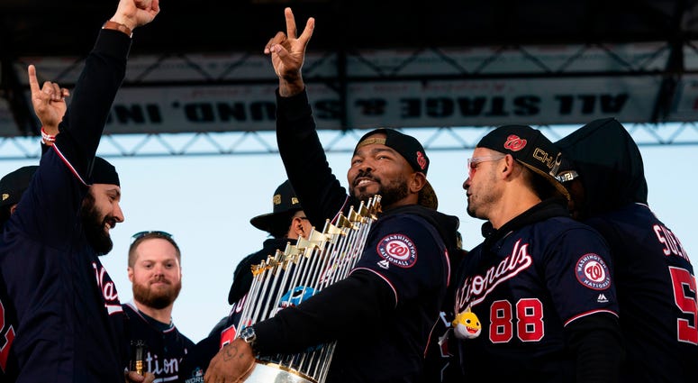 Howie Kendrick with the World Series torphy at the parade. Photos of Nationals' World Series parade are insane