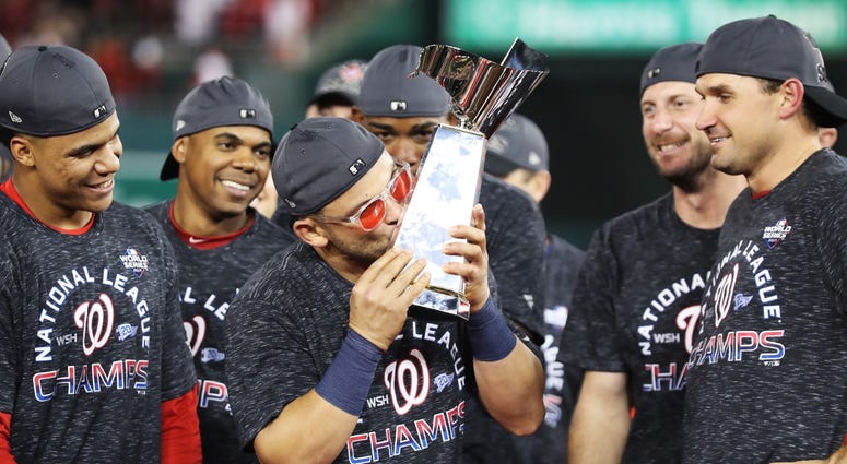 A Baby Shark kiss after sweeping Cardinals in the NLCS. Gerardo Parra celebrates with the trophy after Nationals win Game 4 of the NLCS.