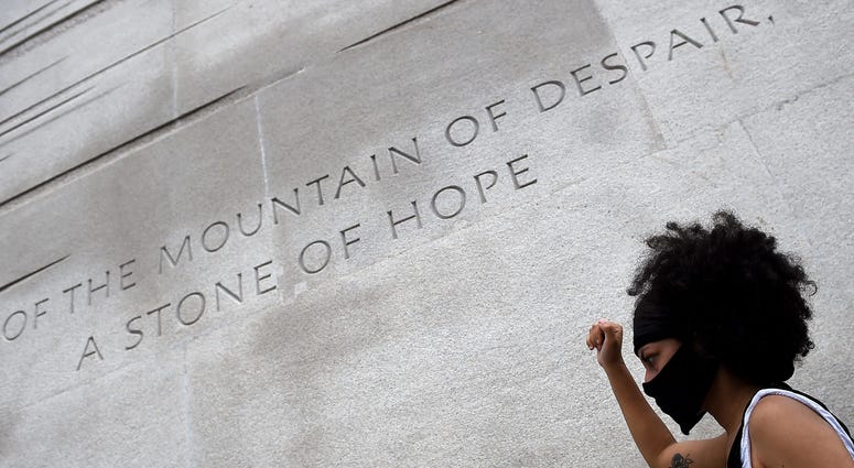 A demonstrator holds up her fist at the Martin Luther King, Jr. Memorial during the Juneteenth march DC's Juneteenth march to the Martin Luther King, Jr. Memorial