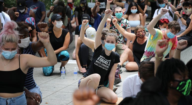 People kneel and raise their fists in the air for eight minutes and 46 seconds – the time that George Floyd was pinned under a police officer's knee – during the march DC's Juneteenth march to the Martin Luther King, Jr. Memorial