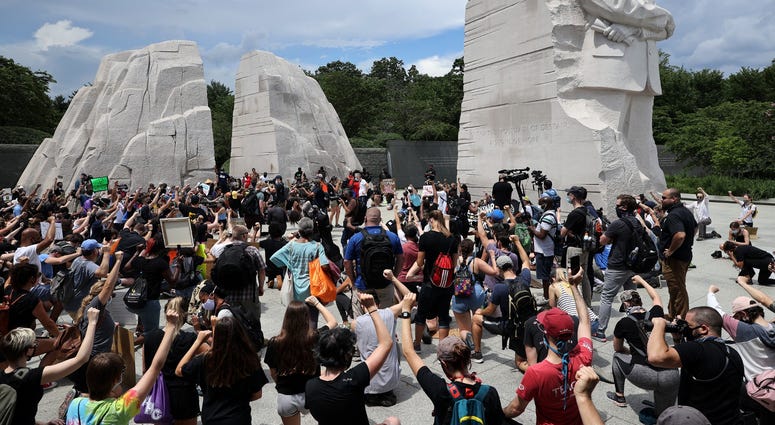 People kneel and raise their fists in the air for eight minutes and 46 seconds DC's Juneteenth march to the Martin Luther King, Jr. Memorial