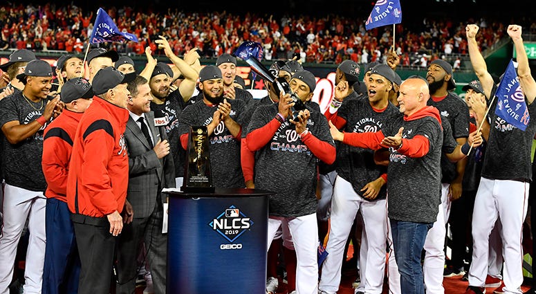 Nationals manager Dave Martinez kisses the NLCS trophy Dave Martinez NLCS Trophy