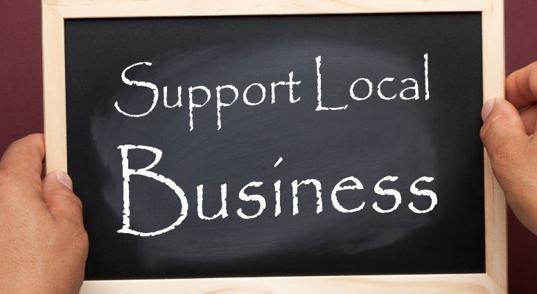 Hands holding blackboard with the text Support Local Business. Business concept.