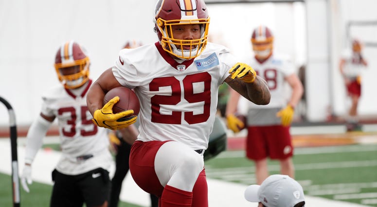 Guice leaps over an assistant at Redskins minicamp Derrius_Guice_Redskins