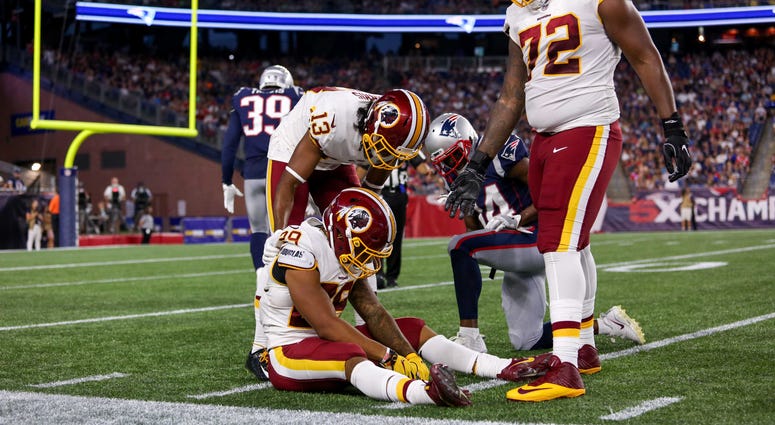 Derrius Guice sits on the turf, injured in Redskins preseason opener Derrius_Guice_Redskins