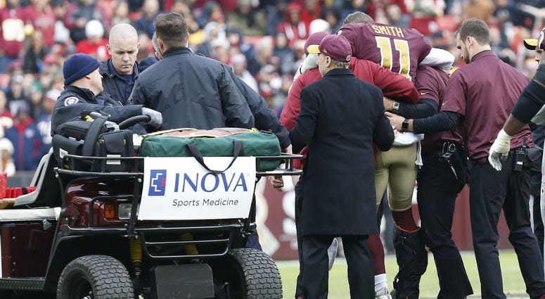 Redskins QB Alex Smith is helped off the field. Redskins_Alex_Smith