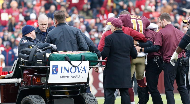Redskins trainers help quarterback Alex Smith onto a cart. Alex_Smith_Injury