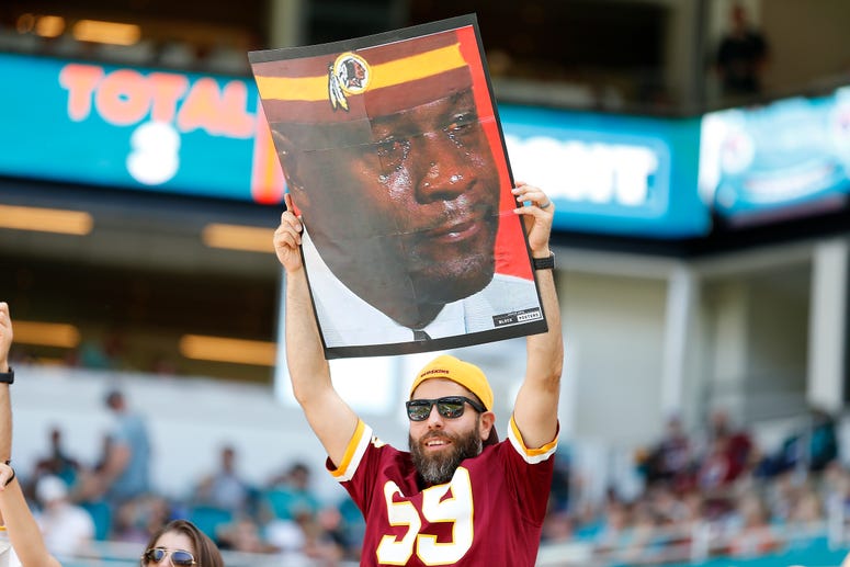 Redskins fan hold Crying Jordan sign. Redskins fans hide faces, protest Bruce Allen in Miami