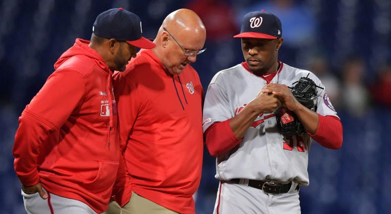 Nationals manager Dave Martinez and trainer Paul Lessard talk to Tony Sipp. Tony_Sipp_Trainer