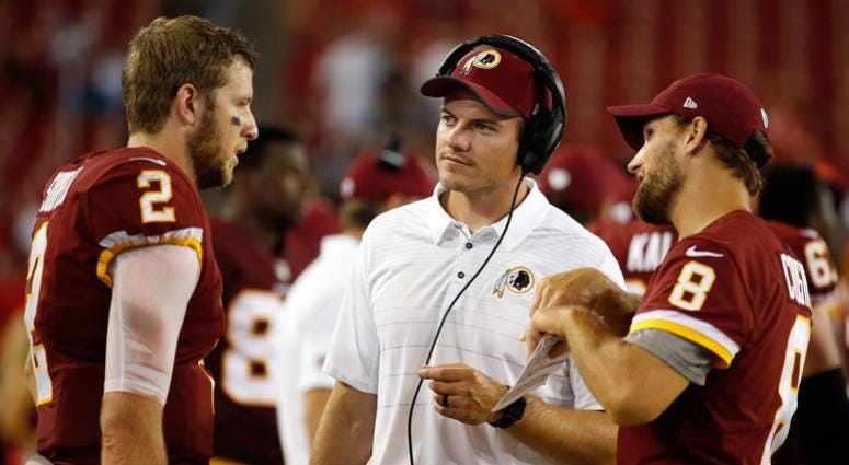 Kevin O'Connell talks with Nate Sudfeld (left) and Kirk Cousins (right) during a 2017 preseason game. Redskins promote Kevin O'Connell to offensive coordinator