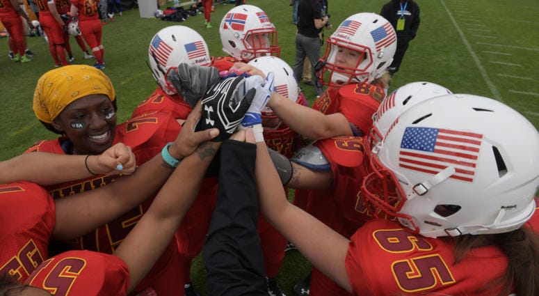 Women's football players huddle up during a game. Womens_Football