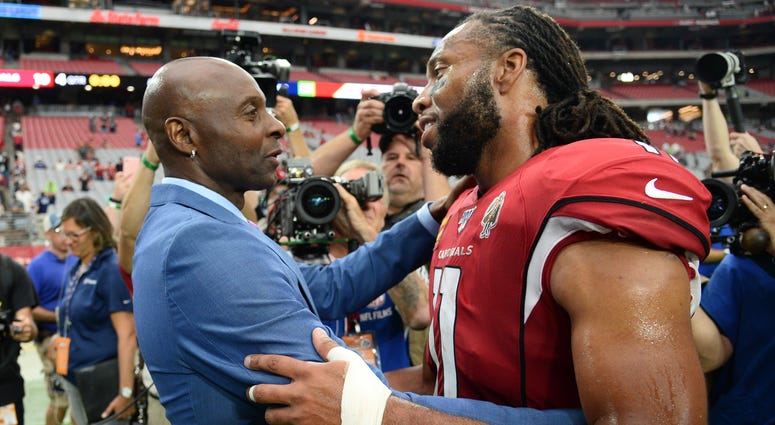 Jerry Rice and Larry Fitzgerald catch up after a game