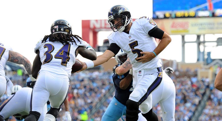 Joe Flacco hands the ball off to Alex Collins