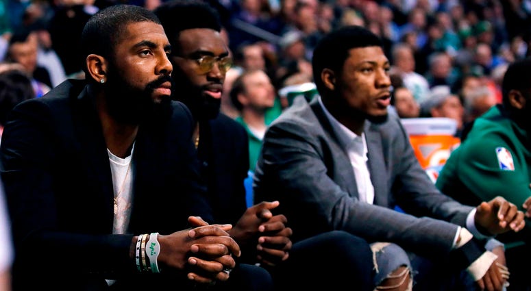 Boston Celtics guard Kyrie Irving, left, sit with teammates Jaylen Brown, center, and Marcus Smart during the first quarter of the team's NBA basketball game against the Oklahoma City Thunder, in Boston, Tuesday, March 20, 2018. Boston Celtics guard Kyrie Irving, left, sit with teammates Jaylen Brown, center, and Marcus Smart during the first quarter of the team's NBA basketball game against the Oklahoma City Thunder, in Boston, Tuesday, March 20, 2018.
