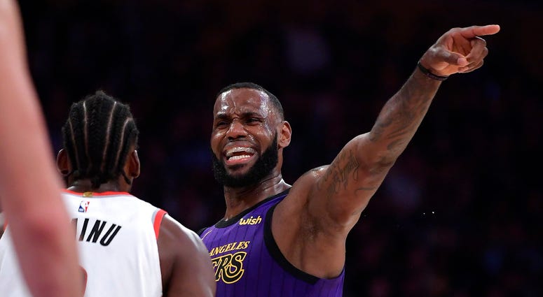 Los Angeles Lakers forward LeBron James, right, gestures to his teammates while being guarded by Portland Trail Blazers forward Al-Farouq Aminu during the second half of an NBA basketball game Wednesday, Nov. 14, 2018, in Los Angeles. The Lakers won 126-1 Los Angeles Lakers forward LeBron James, right, gestures to his teammates while being guarded by Portland Trail Blazers forward Al-Farouq Aminu during the second half of an NBA basketball game Wednesday, Nov. 14, 2018, in Los Angeles. The Lakers won 126-1